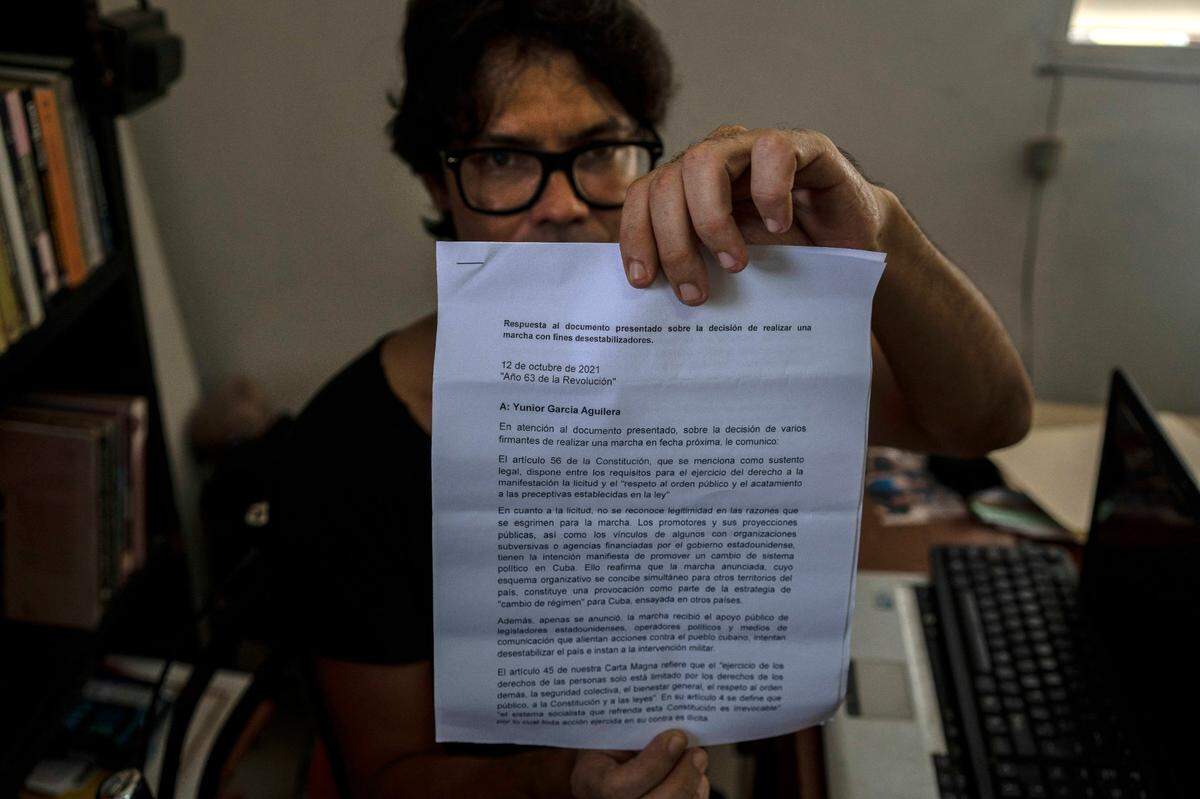 Yunior Garcia Aguilera, playwright and one of the organizers of a protest march, shows a response letter from the government denying them permission to march, during an interview with The Associated Press at his home in Havana, Cuba, Wednesday, Oct. 13, 2021.