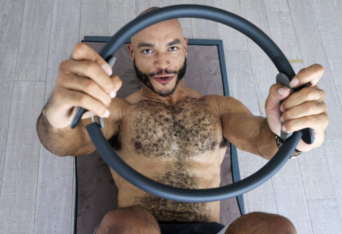 Desmond Bryant, the owner of Hanu Yoga controls his breath as he performs a pose while using a ring during a Pilates class lead by Navy vet and Pilates instructor Shay Williams in Miami Beach, Florida on Sunday, November 9, 2025.