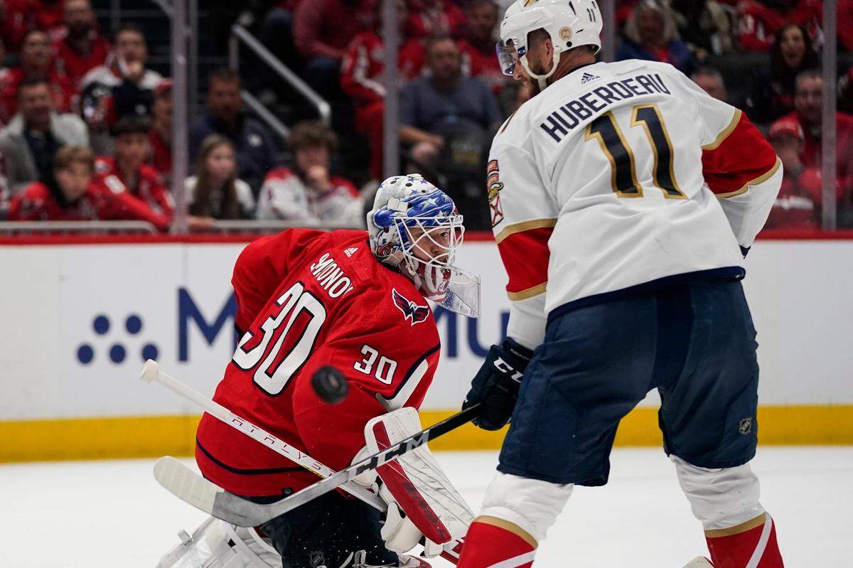 Washington Capitals goaltender Ilya Samsonov (30) and Florida Panthers left wing Jonathan Huberdeau (11) watch as the puck deflects off the pads of Samsonov during the second period of Game 3 in the first-round of the NHL Stanley Cup hockey playoffs, Saturday, May 7, 2022, in Washington. (AP Photo/Alex Brandon)