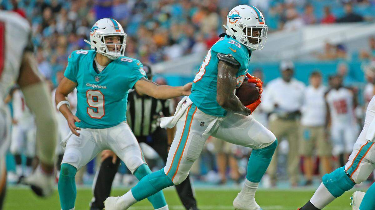 Miami Dolphins quarterback David Fales #9 hand off to  running back Kalen Ballage #33 during first quarter of an NFL football game against the Tampa Bay Buccaneers at Hard Rock Stadium on Thursday, August. 9, 2018, in Miami Gardens.