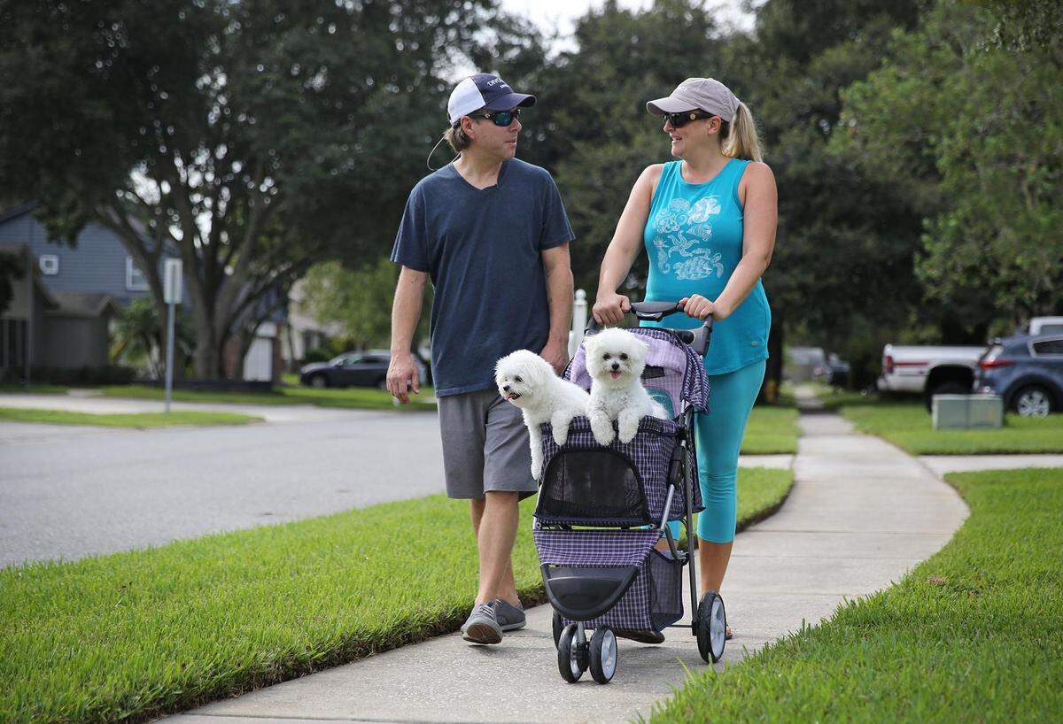 James and Lindsey Johnson walk their dogs, Mako and Kona, in a special dog stroller through their Winter Park neighborhood on Sunday morning, Sept. 27, 2020. The dogs bring the couple much joy and have helped with their grief after they lost their infant son, Cooper Reilly Jonson. Cooper was born on June 13, 2017  and passed away in the hospital 8 days later following severe complications during his delivery.