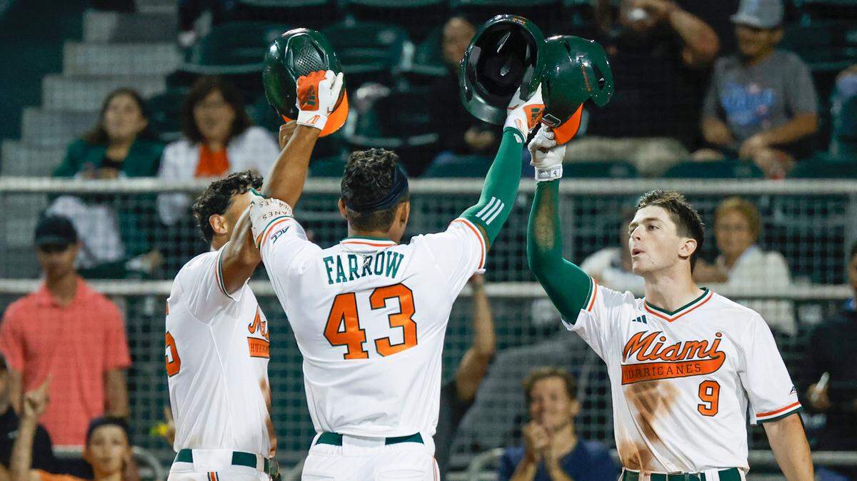 Miami Hurricanes Ian Farrow celebrates his home run with teammates, infielder Yohandy Morales (35) and outfielder Zach Levenson (9) in the eighth inning during the game against Penn State at Mark Light Field at Alex Rodriguez Park in Coral Gables, Florida on Friday, February 17, 2023.