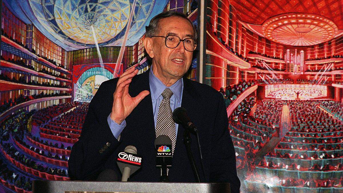 Architect Cesar Pelli briefs reporters in this March 6, 1995, file photo about the details of the performing arts complex in downtown Miami that he designed. Behind him are renderings depicting two interior views. The venue would open in 2006 as the Carnival Center and was quickly renamed the Adrienne Arsht Center for the Performing Arts.