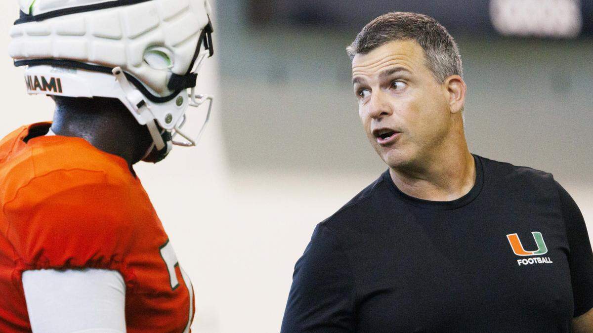 Head coach Mario Cristobal talks to offensive lineman Deryc Plazz (79) during Miami Hurricanes football practice on Monday, Aug. 4, 2025, at University of Miami in Coral Gables, Fla. 