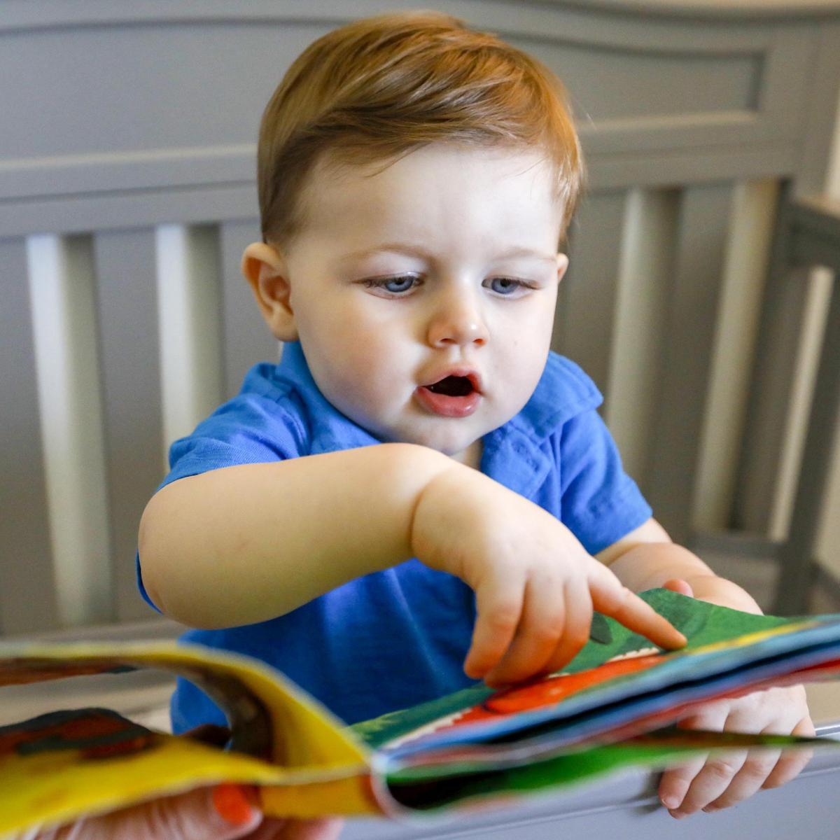 Jude Parker Casanova, a 1-year-old who has never watched a minute of television or played with a phone or tablet, looks over a book in his crib in Miami Lakes, Florida.