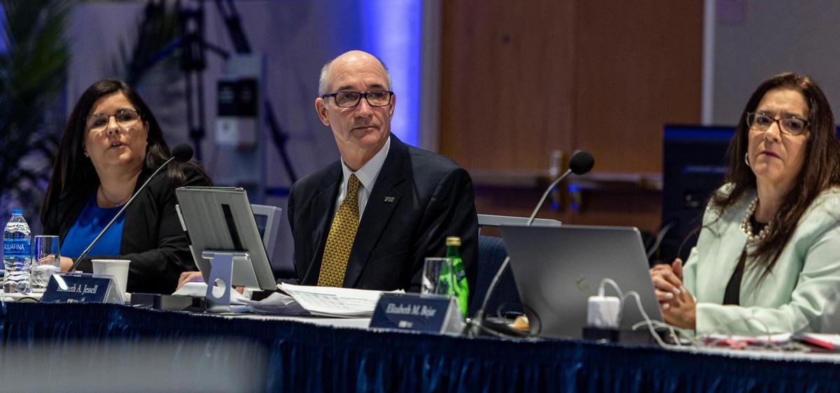 Flanked by Aime Martinez, left, and Elizabeth M. Bejar, right, Florida International University Interim President Kenneth Jessell, center, listens to someone speak during an FIU Board of Trustees meeting at the FIU Modesto A. Maidique Campus on March 3, 2022.