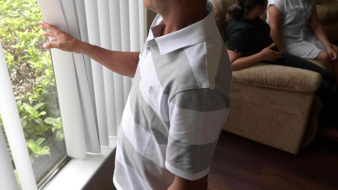 Servando, an undocumented migrant who was separated from his son at the southern border in 2018, looks outside the window of his family’s apartment, Sunday, Aug. 30, 2020, in Orlando.