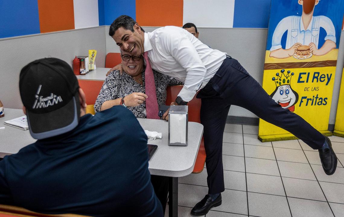 Miami Mayor Francis Suarez hugs Marilys Llanos, a longtime journalist for Telemundo 51 WSCV, at El Rey de la Fritas in Little Havana, on Sept. 14, 2021.