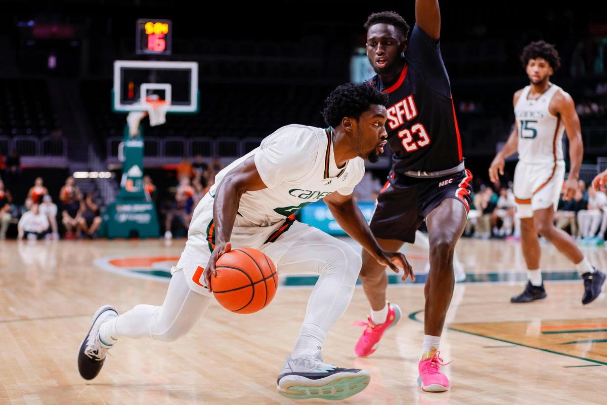Miami Hurricanes guard Bensley Joseph (4) drives to the basket as St. Francis Red Flash guard Wisler Sanon (23) defends during the first half of a basketball game at the Watsco Center in Coral Gables, Florida, on Saturday, December 17, 2022.