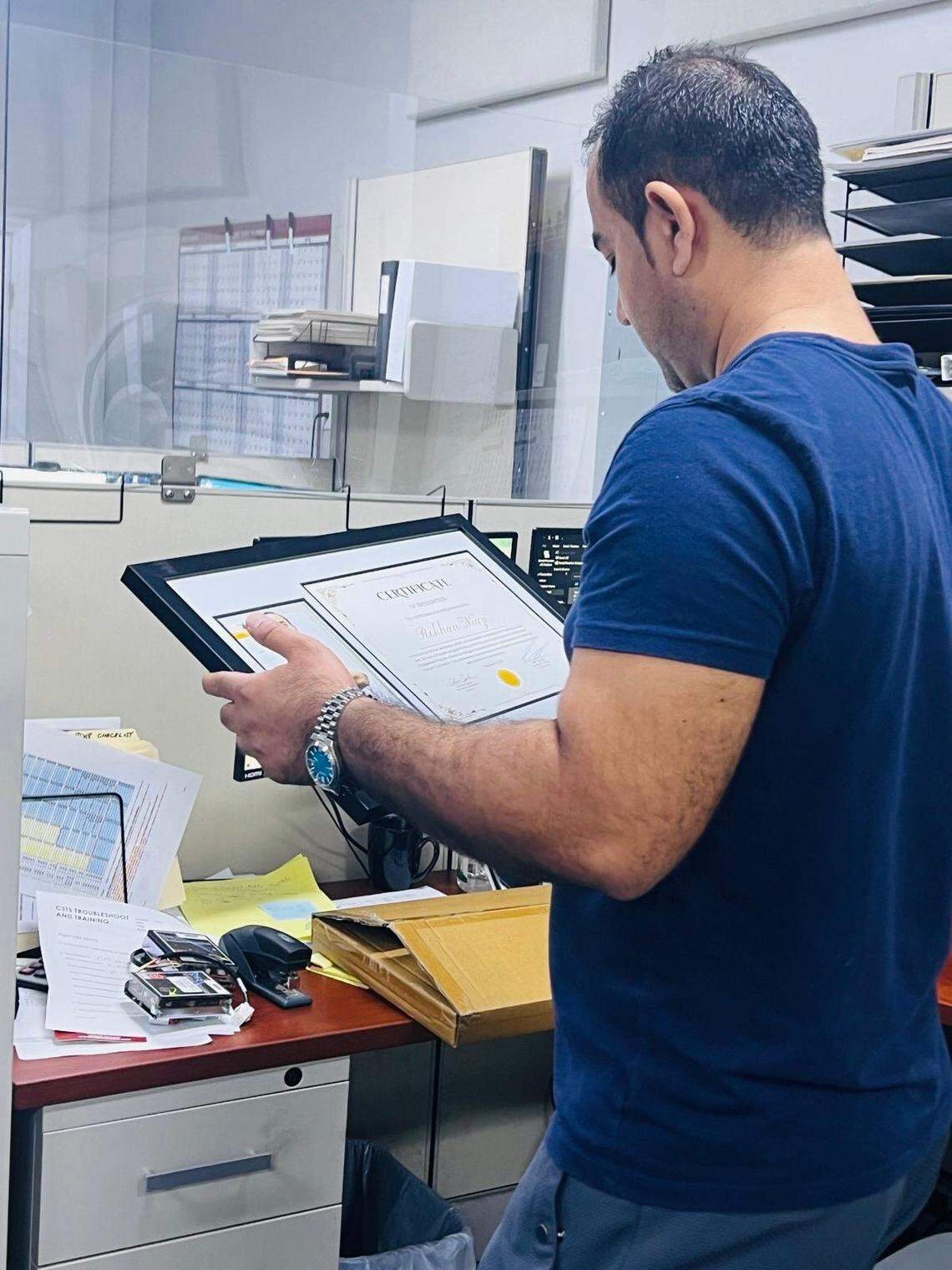 Rohkan Sahel Niazi,32, looks at a certificate he completed.