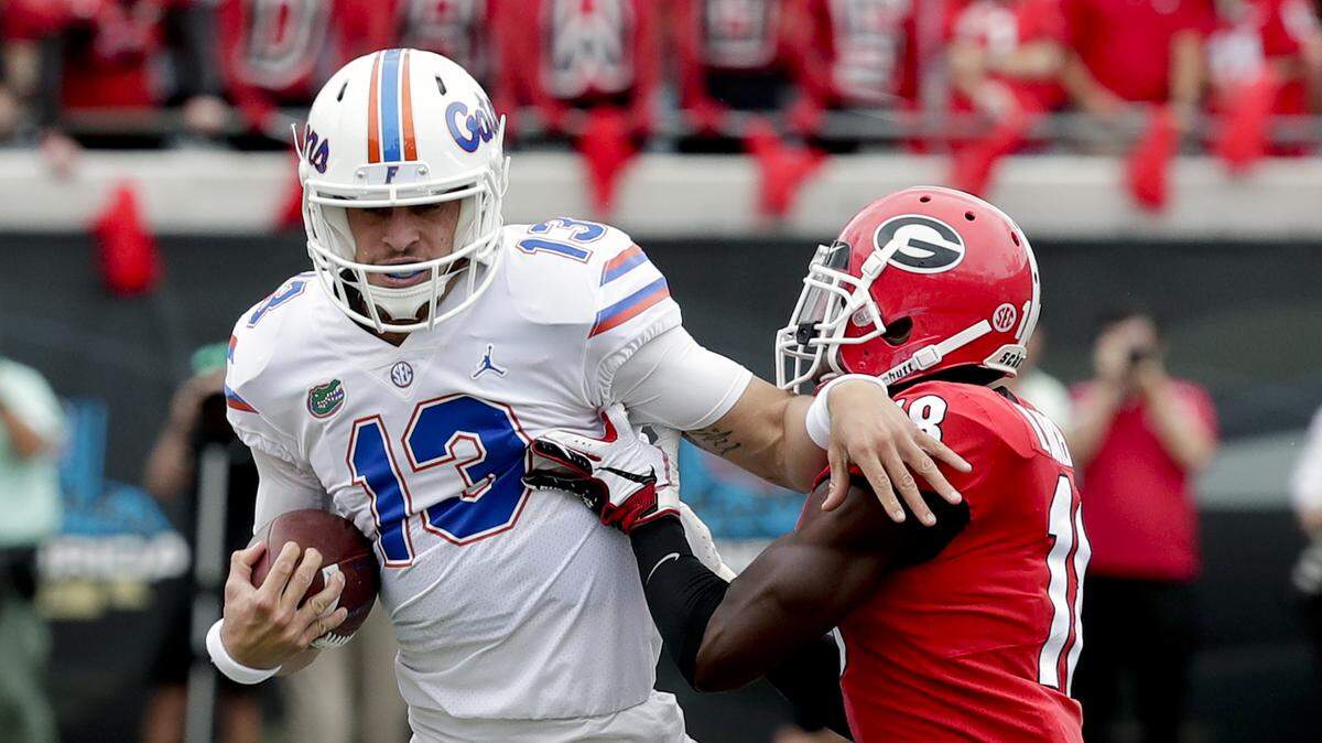Florida quarterback Feleipe Franks (13) is stopped by Georgia defensive back Deandre Baker, right, during the first half of an NCAA college football game Saturday, Oct. 27, 2018, in Jacksonville, Fla.