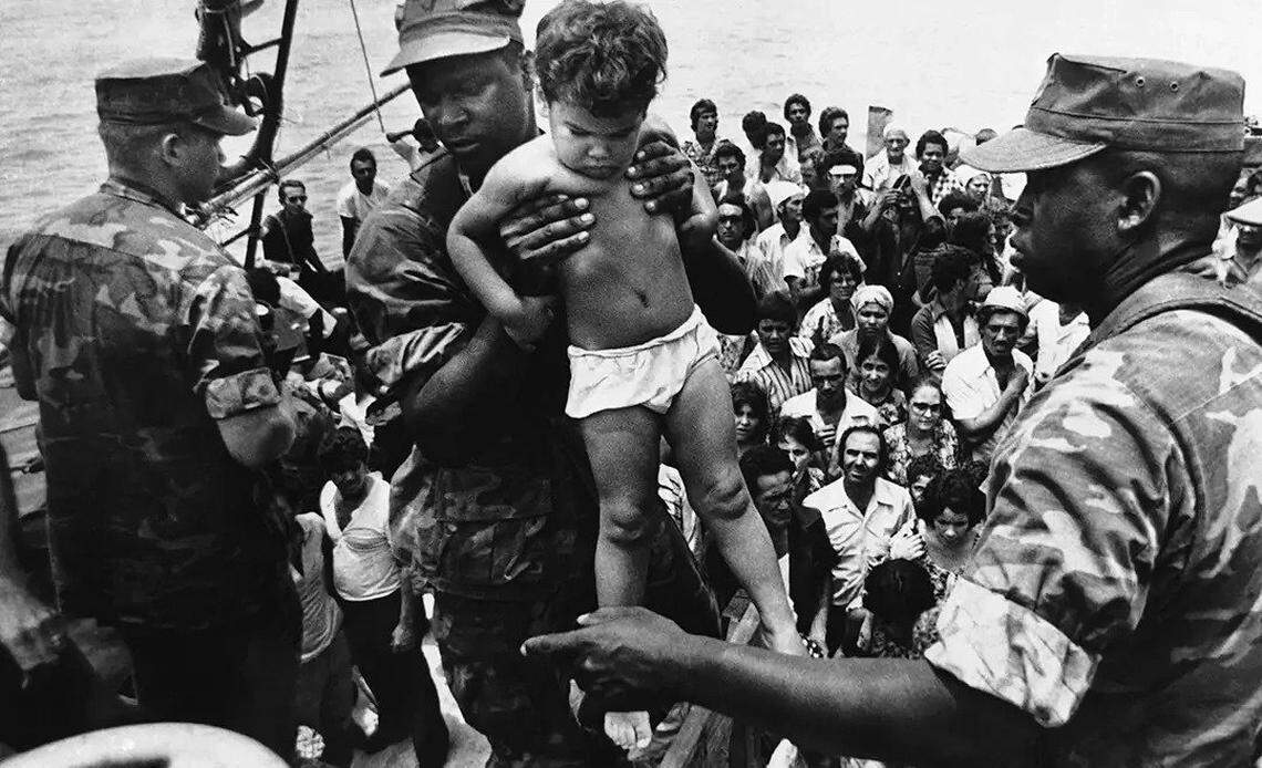 A U.S. Marine helps a child off of a Cuban refugee boat during the Mariel boatlift.