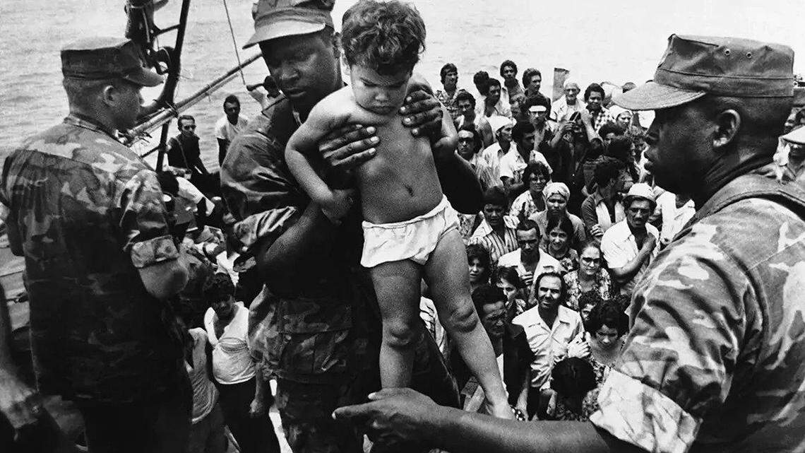 A U.S. Marine helps a child off of a Cuban refugee boat during the 1980 Mariel boatlift.