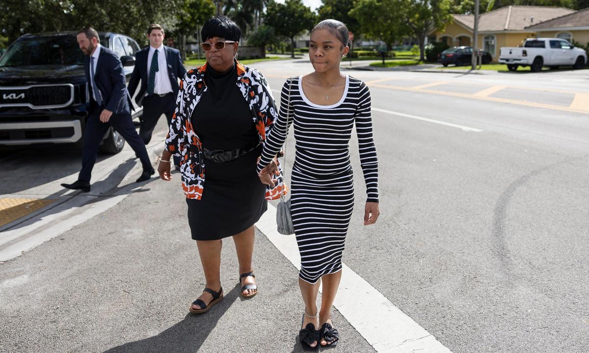 Robin Gore, left, and Jaquandra White, center, the mother and sister of Taborez White, who was killed in a shooting at Cedar Grove Apartments, leave after attending a press conference outside the neighborhood on Wednesday, Oct. 23, 2024, in Miami Gardens, Fla. The event announced a lawsuit filed against the apartment’s property management following three shootings at the complex that left two dead and one injured.