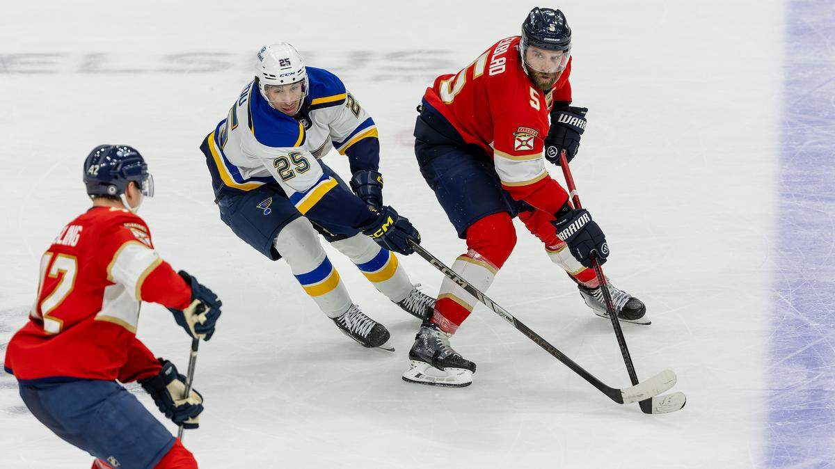 Florida Panthers defenseman Aaron Ekblad (5) passes the puck to teammate Gustav Forsling (42) as St. Louis Blues center Jordan Kyrou (25) defends during the third period of an NHL game at Amerant Bank Arena on Friday, Dec. 20, 2024, in Sunrise, Fla.