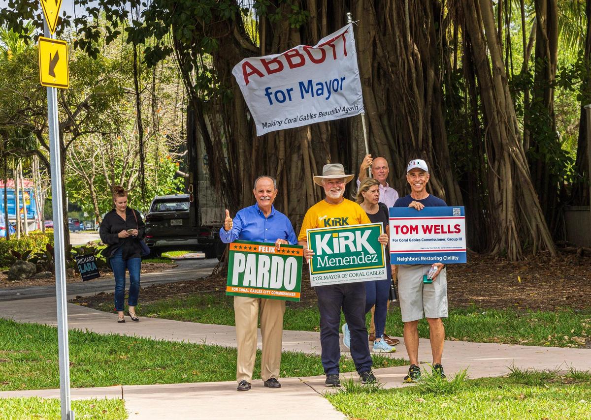 Candidates, from left to right: Felix Pardo, running for commissioner; Commissioner Kirk Menendez, running for mayor; Michael Abbott (back), running for mayor; and Tom Wells, running for commissioner, campaigned outside of the Coral Gables Country Club poll site on Tuesday, April 8, 2025.
