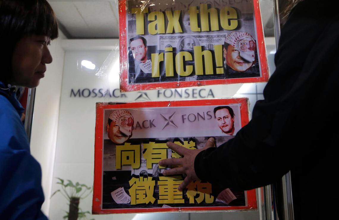 Placards featuring portraits of Chinese President Xi Jinping and British Prime Minister David Cameron are displayed near the regional office of Panama-based law firm Mossack Fonseca in Hong Kong, Tuesday, April 12, 2016. The Panama Papers showed the brother-in-law of Chinese President Xi Jinping and relatives of other members of the ruling elite owned offshore companies.