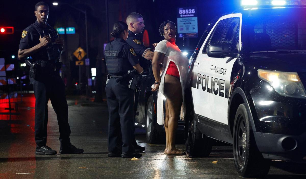 A woman is detained by Miami Beach police during spring break on Miami Beach, Florida on Saturday, March 16, 2024.