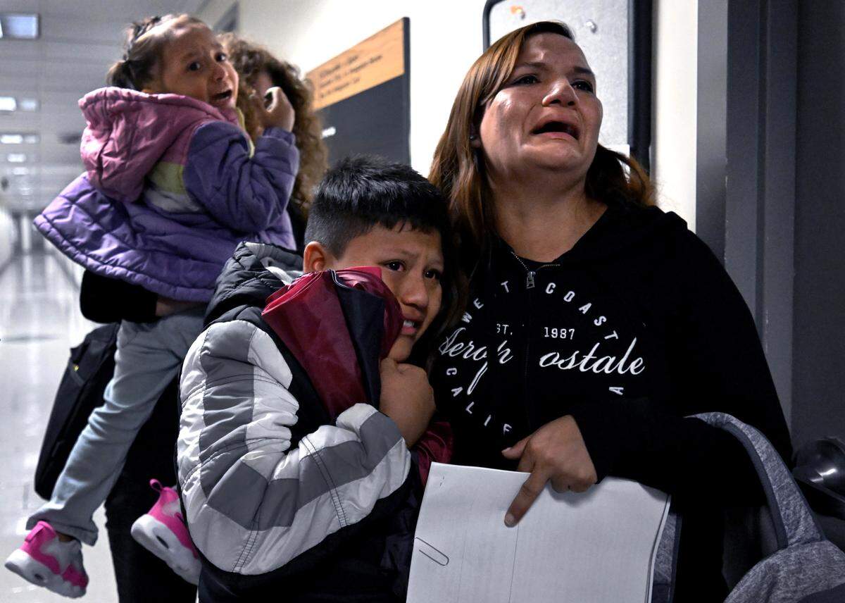 A migrant woman and her children from Ecuador weep after her husband was detained by ICE agents and federal officers after their immigration court hearings at the Jacob K. Javits Federal Building in New York on Aug. 20, 2025.  