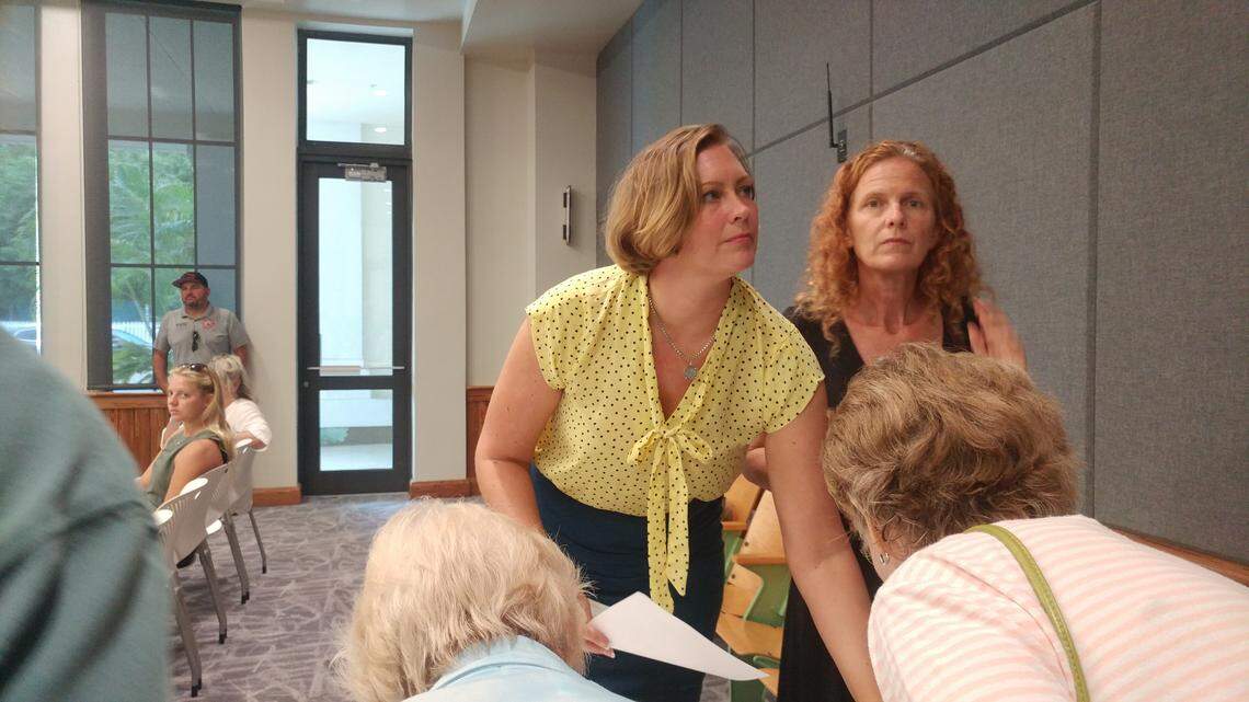 Gigi Varnum, left, hands out agendas to people attending a meeting about Key West Cares, the local relief effort for the people of the Bahamas suffering from the devastation of Hurricane Dorian.