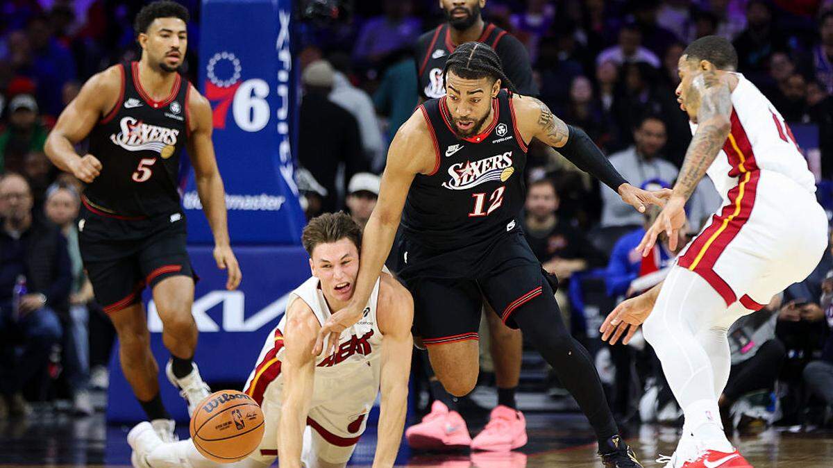  Trendon Watford #12 of the Philadelphia 76ers scrambles for the ball against Pelle Larsson #9 of the Miami Heat during the second quarter at Xfinity Mobile Arena on November 23, 2025 in Philadelphia.