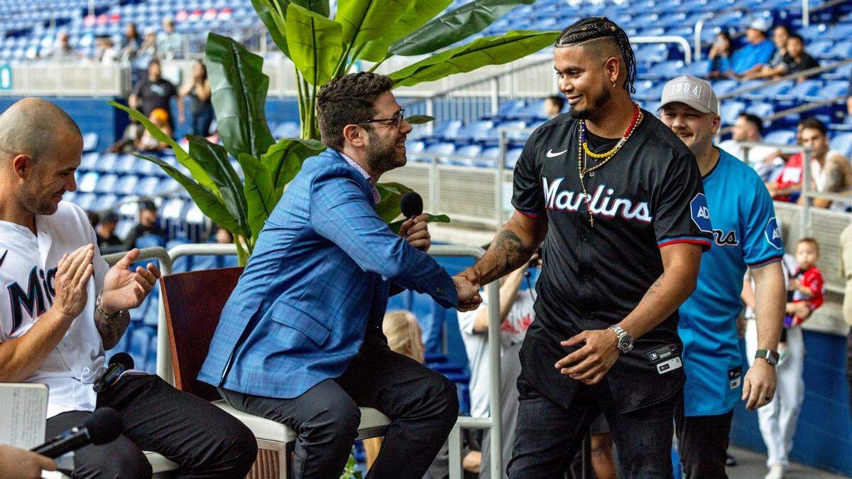 New Marlins General Manager Peter Bendix shakes hands with infielder Luis Arraez as he and Jake Burger introduce next season’s uniform during the Miami Marlins FanFest event at loanDepot park in Miami, Florida on Friday, January 26, 2024.
