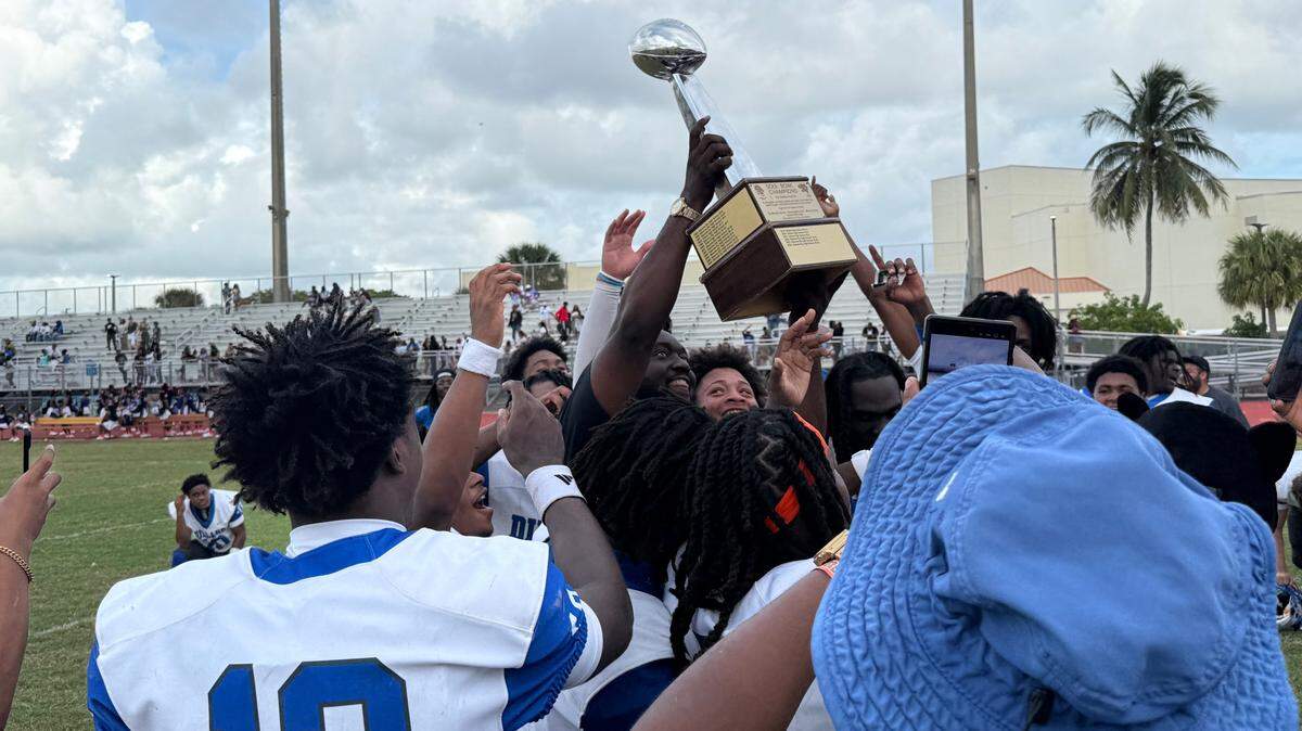 The Dillard Panthers hoist the Soul Bowl trophy after 35-0 victory over Blanche Ely on Saturday.