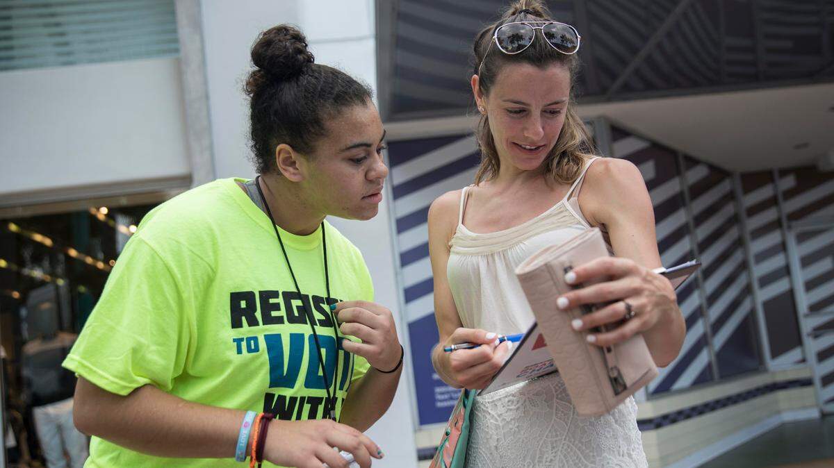 Hannah Karcinell, 18, a recent graduate of Marjory Stoneman Douglas High School, helps Miriahjo Reiss, 25, to register to vote on Lincoln Road in Miami Beach on Sunday, June 24, 2018. The South Beach event was the first stop on the Florida leg of group's “Road to Change” tour,  where they aim to educate Floridians, across all 27 congressional districts about gun violence, and register voters before mid-term elections.