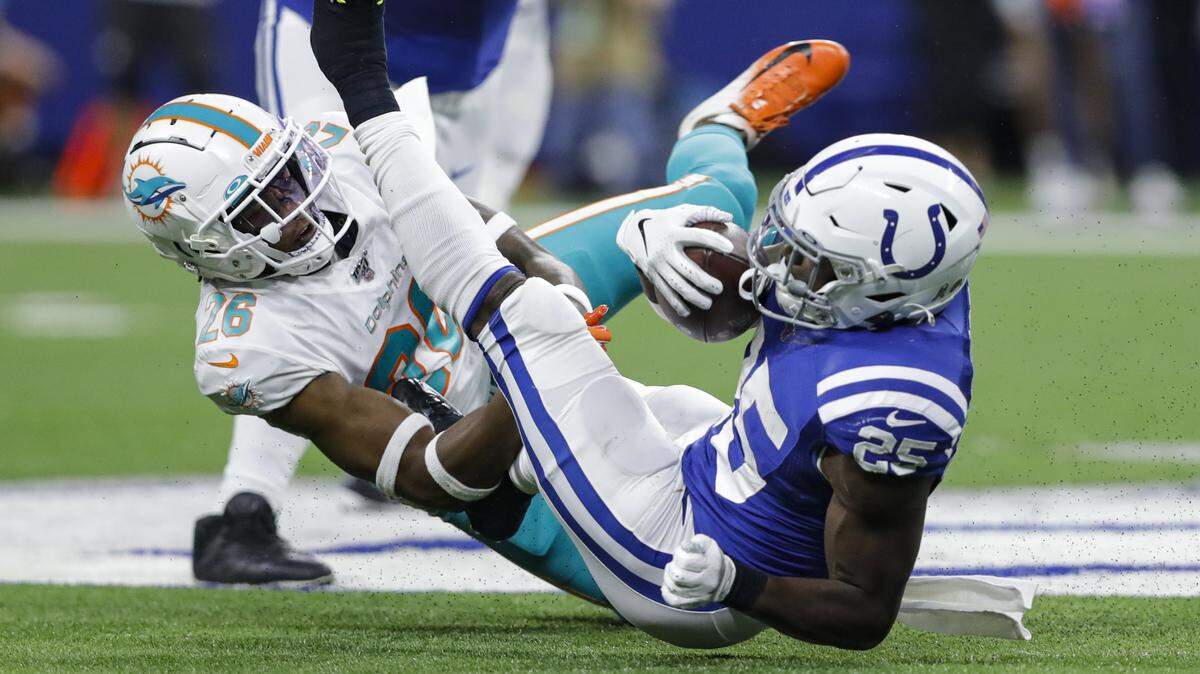 Indianapolis Colts running back Marlon Mack (25) is tackled by Miami Dolphins defensive back Steven Parker (26) during the first half of an NFL football game in Indianapolis, Sunday, Nov. 10, 2019.