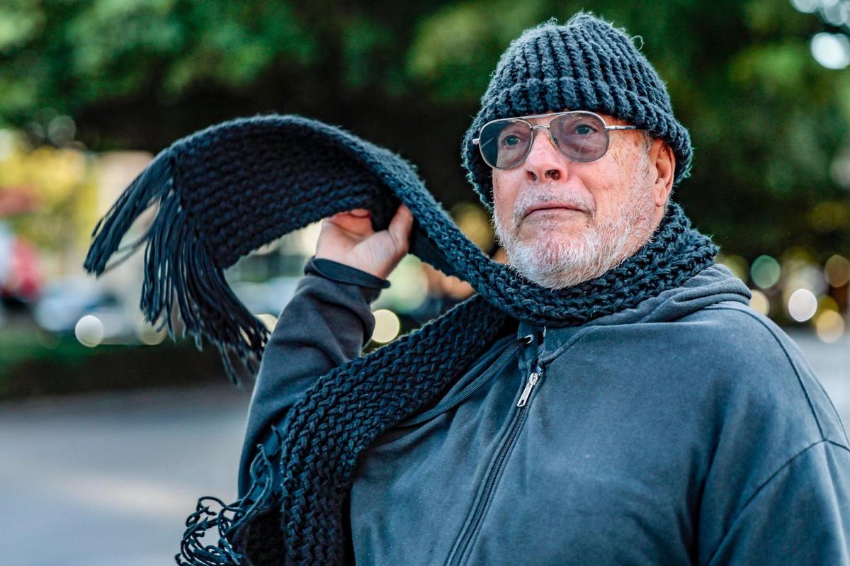 James Martinelli flips his scarf to stay warm while walking along Coral Way as the coldest air of the season arrives in South Florida on Wednesday morning, Jan. 8, 2025.