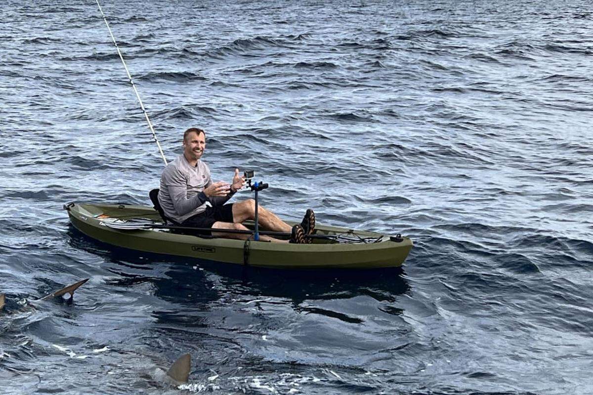 Mike Heithaus is surrounded by sharks while on a kayak in a rough ocean