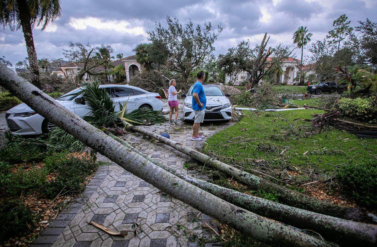 Marie Cook and a neighbor Dean Vocaturo survey the damage caused by a tornado to her home and many others in the The Preserve community Oct 09, 2024 in Wellington.