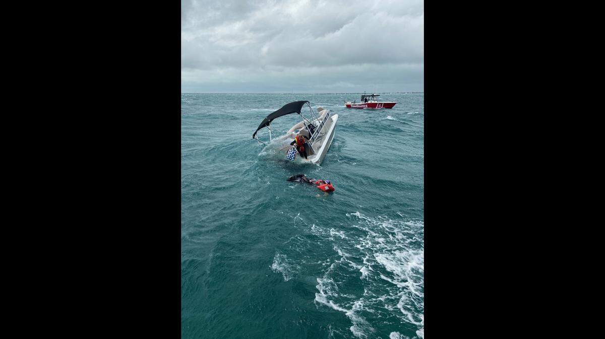 Two people abandon a vessel taking on water near Windley Island, Florida, to swim toward a Coast Guard Station Islamorada 45-foot Response Boat near Alligator Key Lighthouse on Nov. 9, 2019.