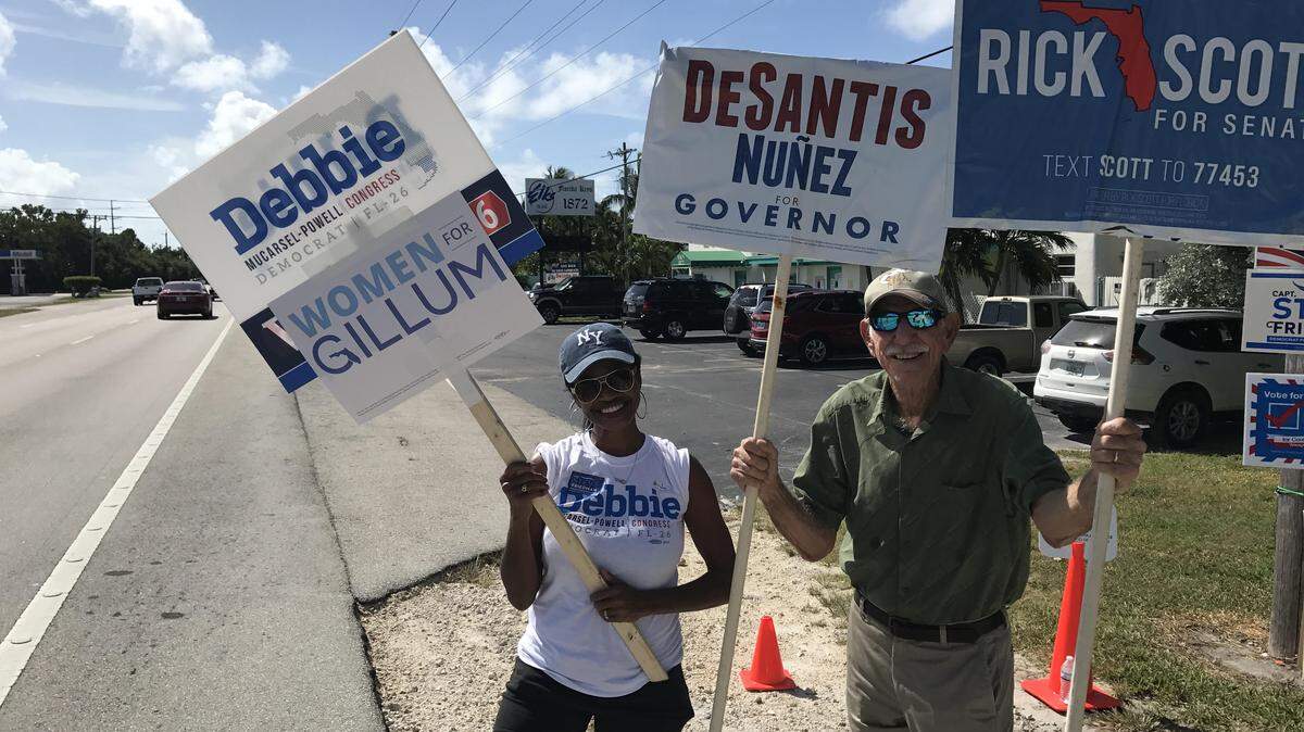 Charmaine Gittens, a Democrat, and Fred Nickerson, a Republican, wave political signs on the side of U.S. 1 in Tavernier in the Upper Florida Keys Tuesday, Nov. 6. Despite their opposing political views, they both said they enjoyed each other’s company as they campaigned for their respective candidates.