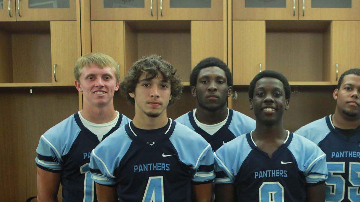 Coral Springs Charter School coach Adam Miller is shown with players (left to right) Joe McChrystal, Steve St. Cyr, Jordan Ebanks, Ross Kuruc and Denzel Butler on August 10, 2013 during the Miami Dolphins High School Football Media Day at Sun Life Stadium.
