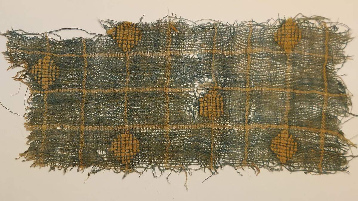 A blue fabric with a gold pattern found at Aravah.