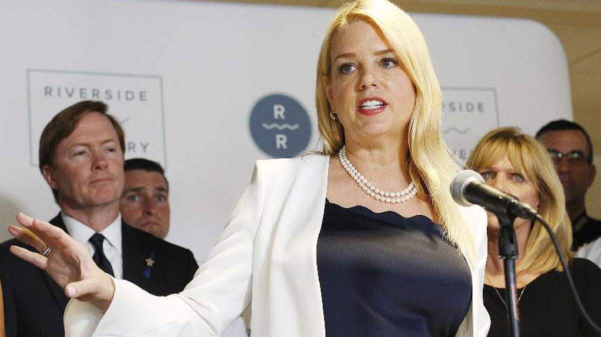 Attorney General Pam Bondi gives a press conference Tuesday at Riverside Recovery of Tampa announcing that her office has filed a lawsuit against five large drug manufacturers and distributors of opioids. She is flanked by Commissioner of Agriculture Adam Putnam, state and local government officials, and families affected by the opioid epidemic.