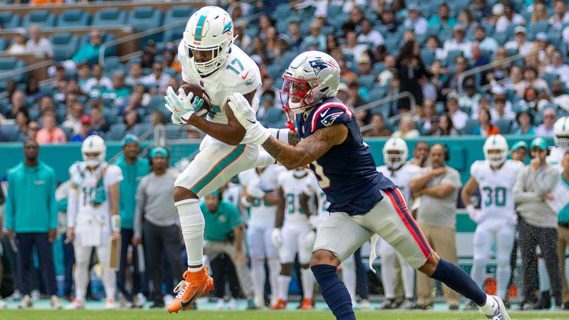 Miami Dolphins wide receiver Jaylen Waddle (17) catches a pass as New England Patriots cornerback Christian Gonzalez (0) defends in the first half of their NFL game at Hard Rock Stadium on Sunday, Nov. 24, 2024, in Miami Gardens, Fla