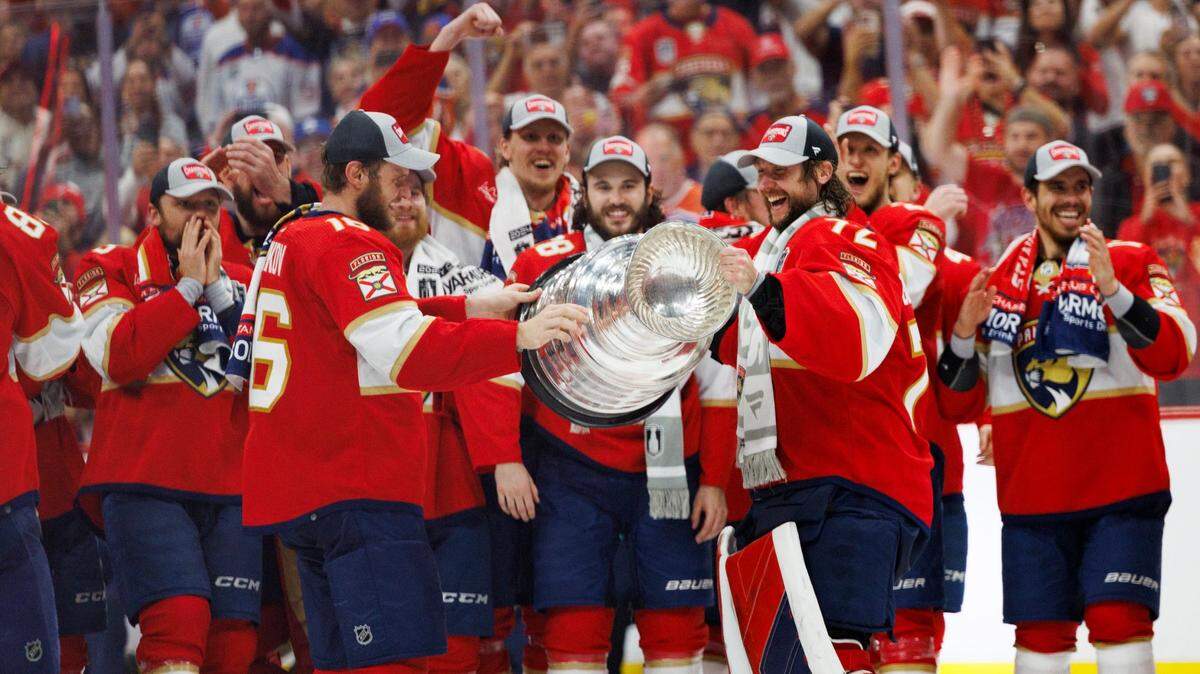 Florida Panthers captain Aleksander Barkov (16) passes the cup to goaltender Sergei Bobrovsky (72) after the Florida Panthers won Game 7 of the NHL Stanley Cup Final at the Amerant Bank Arena on Monday, June 24, 2024 in Sunrise, Fla.