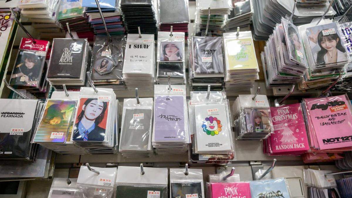 In this photo taken on November 22, 2024, trading cards released by K-pop groups and solo acts are seen on display in a retail store in Seoul. As K-pop's global popularity grows unabated, so has a mountain of discarded CDs and merchandise waste. More than 115 million K-pop CDs were sold in 2023, the first time sales breached the 100 million mark for the industry. (Photo by ANTHONY WALLACE / AFP) / To go with AFP story PLASTIC-ENVIRONMENT-SKOREA-K-POP, FOCUS  by Hieun Shin (Photo by ANTHONY WALLACE/AFP via Getty Images)