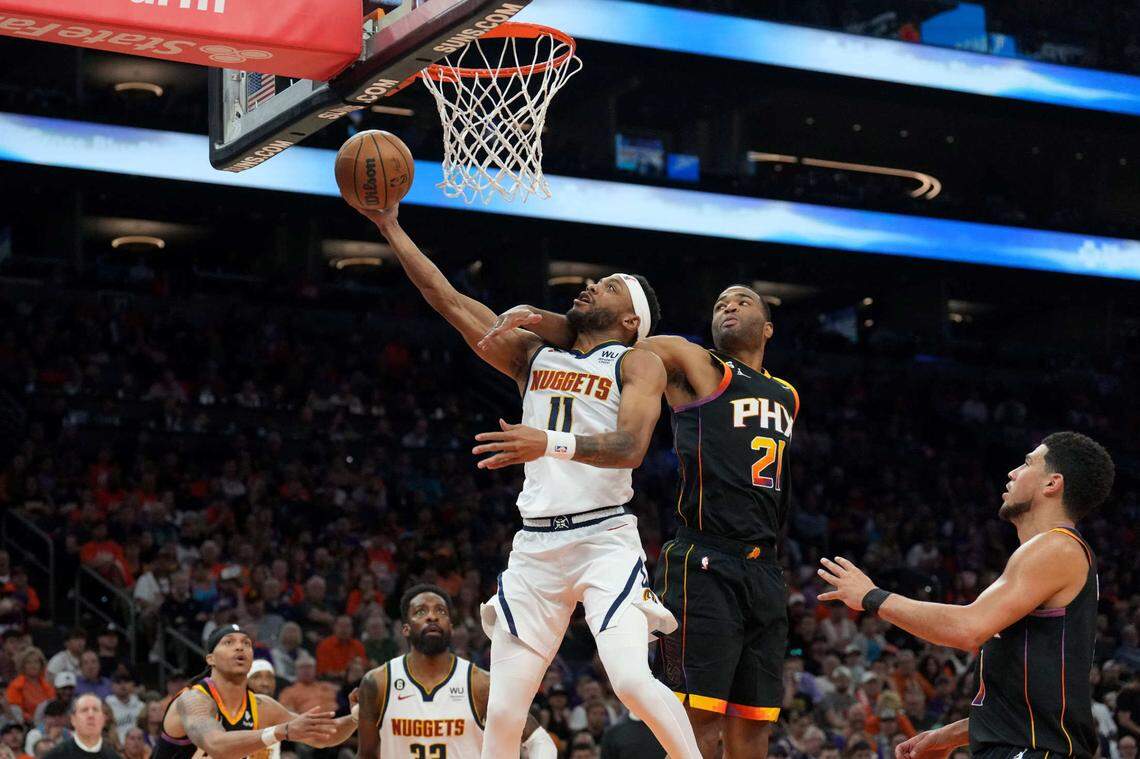 May 11, 2023; Phoenix, Arizona, USA; Denver Nuggets forward Bruce Brown (11) puts up a layup against Phoenix Suns forward T.J. Warren (21) during the second half of game six of the 2023 NBA playoffs at Footprint Center. Mandatory Credit: Joe Camporeale-USA TODAY Sports