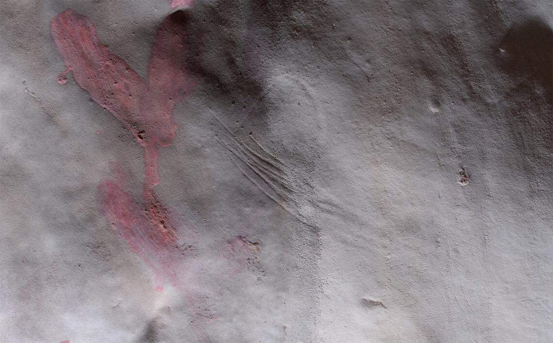 A splash of red and long scratched marks directed researchers toward the ancient artwork.