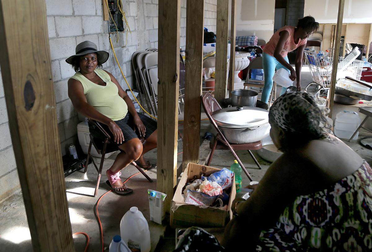 Haitian women cook in an improvised kitchen at the New Haitian Mission Church used as a shelter close to Sand Banks neighborhood where mostly Haitians lives on the the S.C.Bootle Highway on Treasure Cay in Abaco, that was totally destroyed by Hurricane Dorian as devastated The Bahamas, on Wednesday, September 12, 2019.