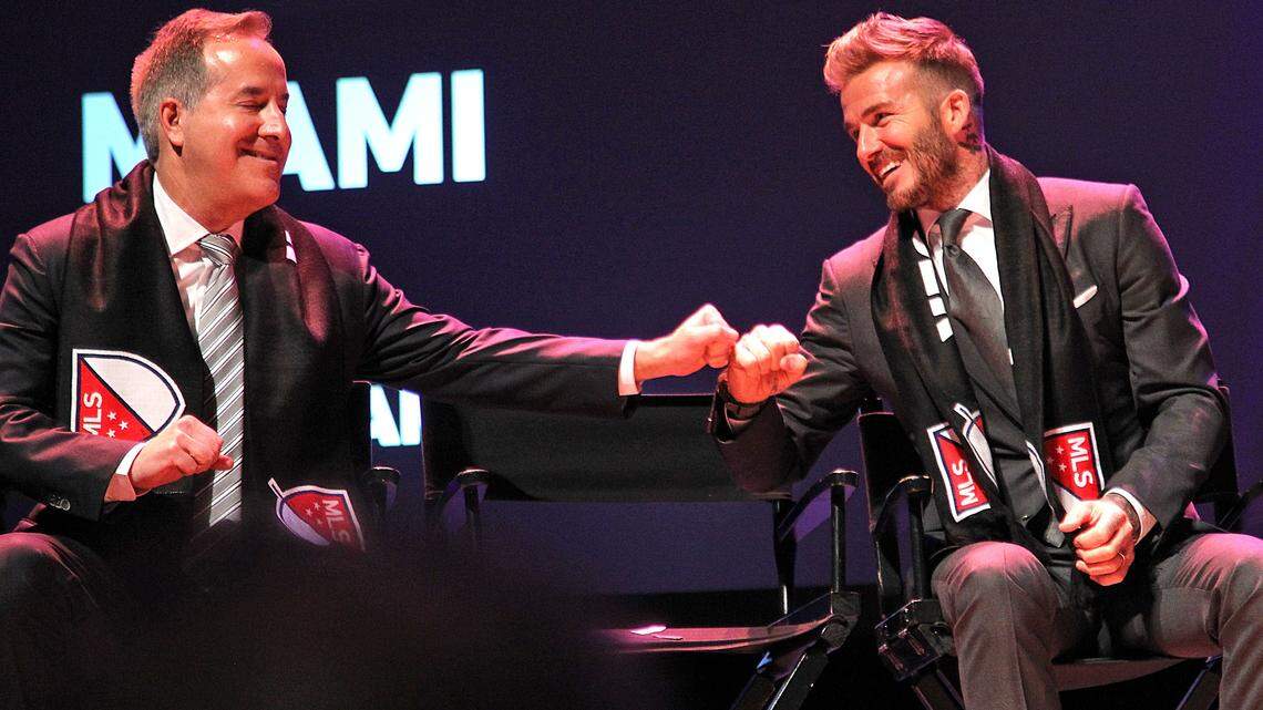 Jorge Mas y David Beckham (der.) celebran el anuncio del nuevo equipo de MLS en Miami el 2018 en  The Adrienne Arsht Center. De modo subliminar se puede apreciar los colores del equipo.
