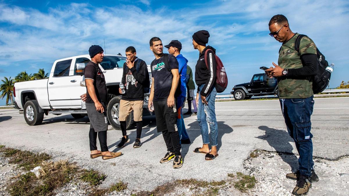 Miembros de dos grupos de migrantes cubanos procedentes de Matanzas –uno con 19 personas, el otro con 12– permanecen de pie bajo el sol a un lado de la carretera U.S. 1 en la isla de Duck Key, en los Cayos Medios, el lunes por la mañana. Al mediodía, dijeron que han estado parados allí esperando ser recogidos por agentes de la Patrulla Fronteriza de Estados Unidos desde que llegaron en dos embarcaciones rústicas a las 2:30 a.m. del 2 de enero de 2023.
