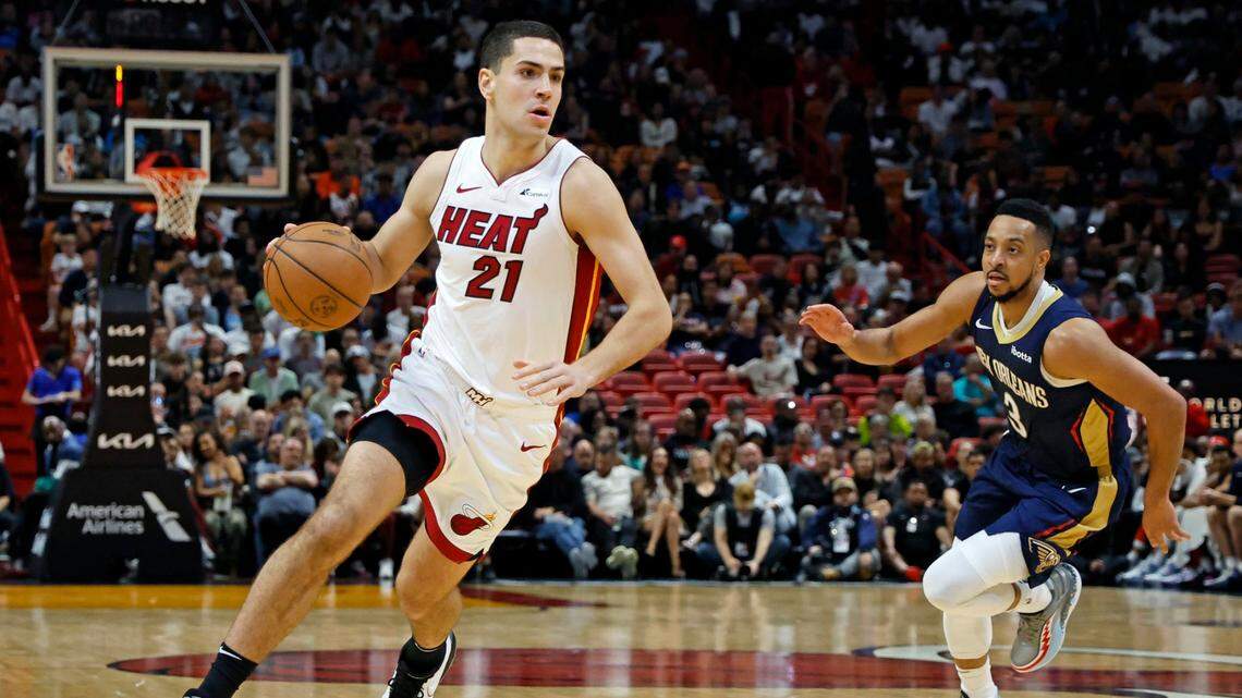 Miami Heat forward Cole Swider (21) drives the ball as New Orleans Pelicans guard CJ McCollum (3) gives chase in the fourth quarter at Kaseya Center in Miami on March 22, 2024.