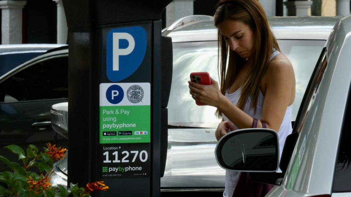 A woman in Coral Gables uses PayByPhone to pay for meter parking.