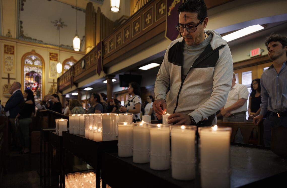 Danny Mendes lights a candle for prayer during Ash Wednesday mass on Wednesday, Feb. 18, 2026, at Gesu Catholic Church in downtown Miami. The mass was fully packed with standing room only at the back of the church. 
