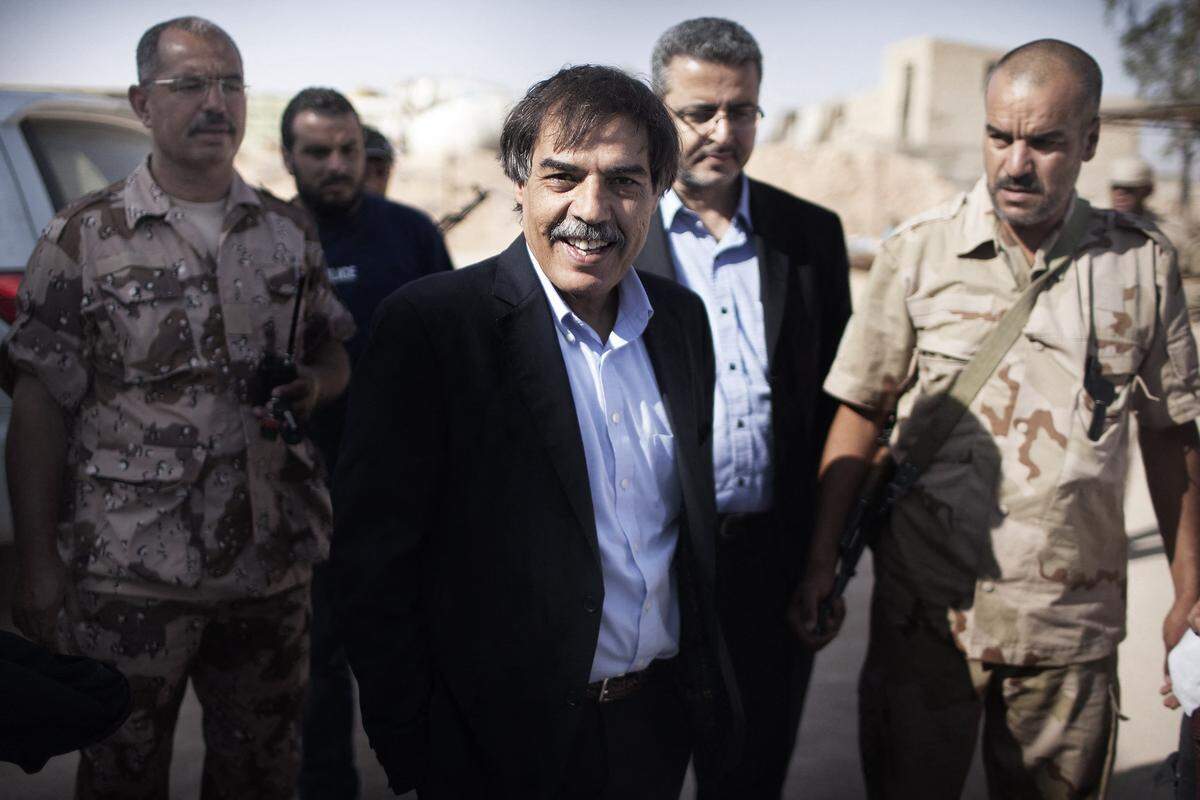 National Transitional Council Minister for Oil and Finance Ali Tarhouni (c) arrives at the Military Council offices in Zintan, the rebel stronghold on the Western Libyan front July 12, 2011. (Photo by MARCO LONGARI/AFP via Getty Images)