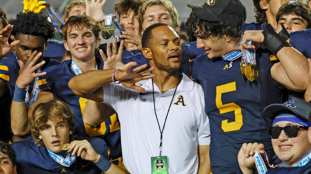St. Thomas Aquinas Nicholas Rodriguez (5) joins coach Roger Harriott who flashes five fingers signifying a total of five consecutive state championship wins after defeating the Homestead Broncos in the Class 3M state championships at Bragg Memorial Stadium in Tallahassee, Florida on Saturday, December 9, 2023.